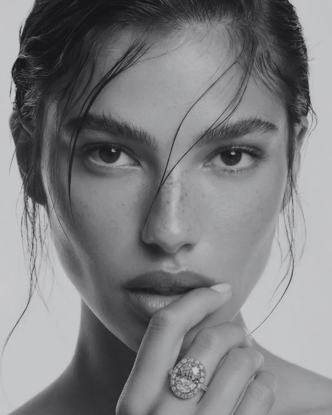 A woman with clean skin touching her face, skincare